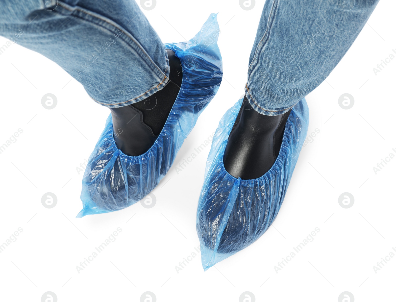Photo of Woman wearing blue shoe covers onto her boots against white background, top view
