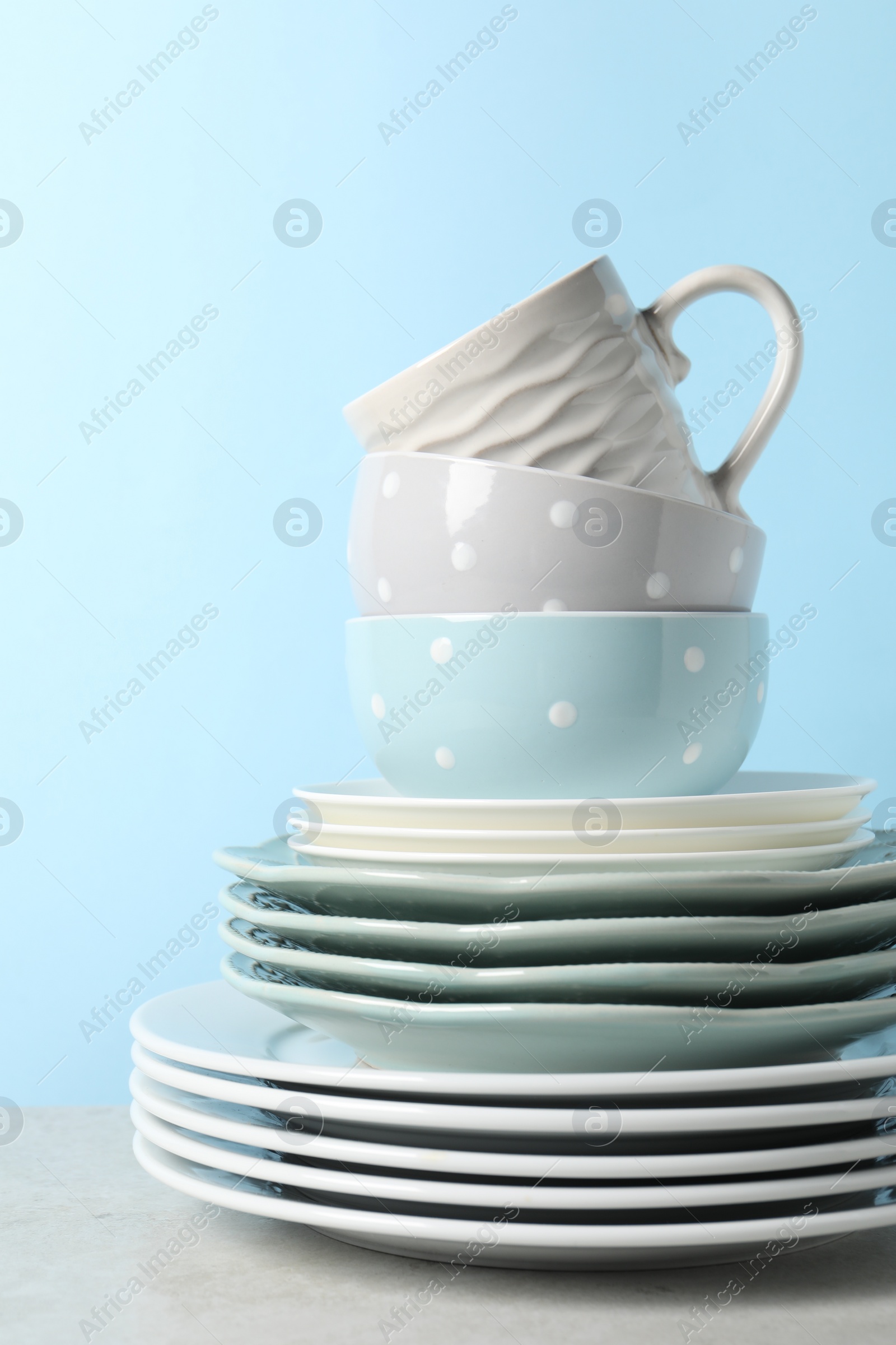 Photo of Beautiful ceramic dishware and cup on light grey table