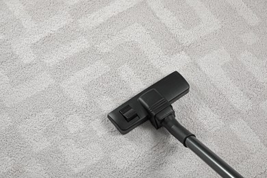 Photo of Removing dirt from white carpet with modern vacuum cleaner, above view. Space for text
