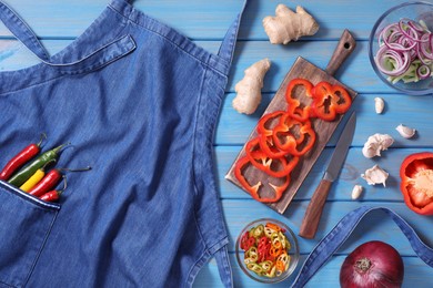Photo of Flat lay composition with denim apron and different ingredients on light blue wooden table