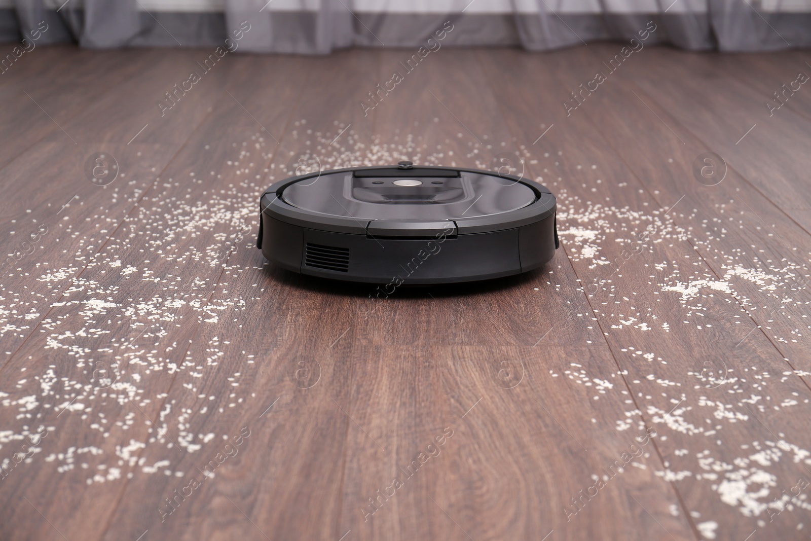 Photo of Removing groats from wooden floor with robotic vacuum cleaner at home