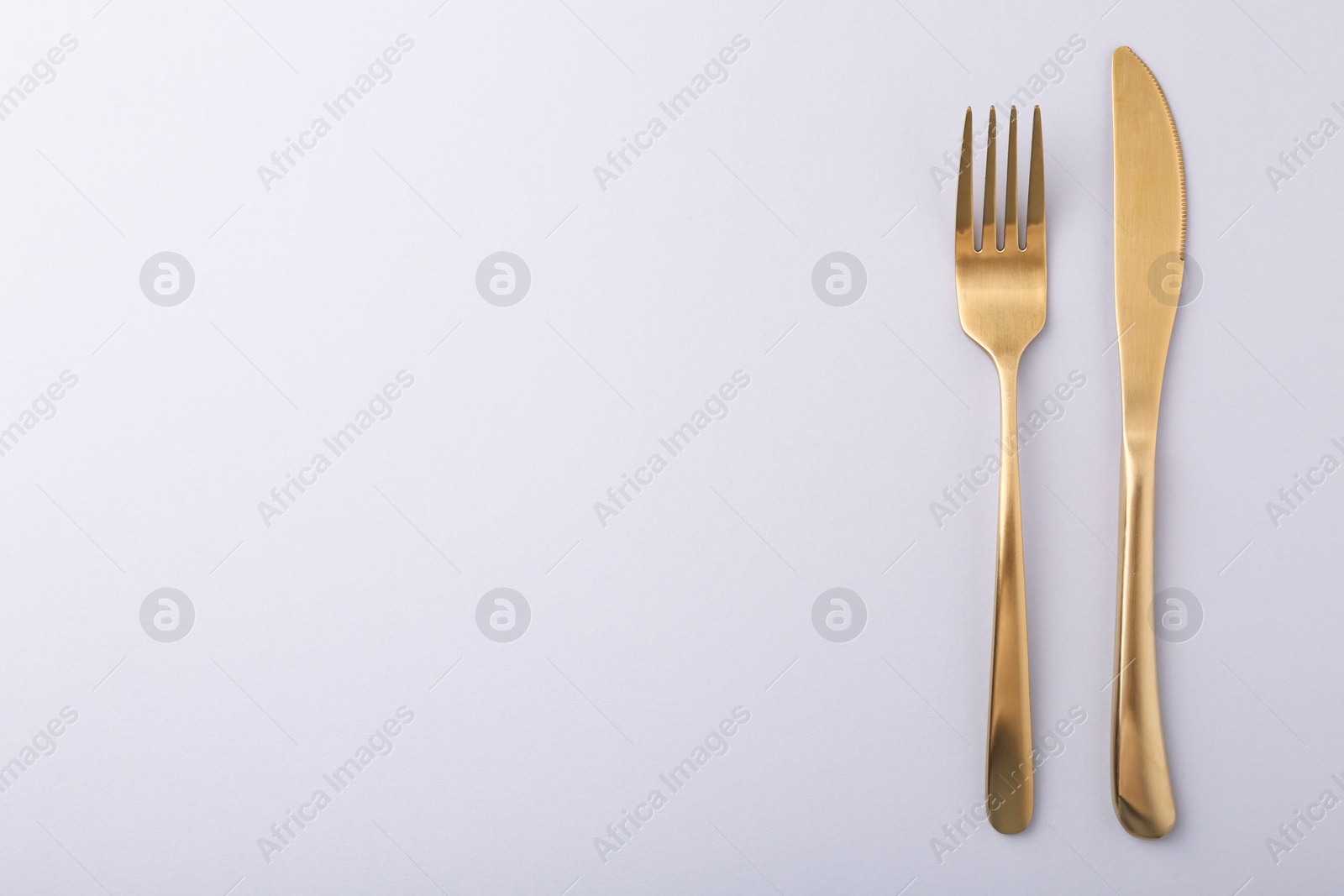 Photo of Stylish cutlery on grey table, top view. Space for text