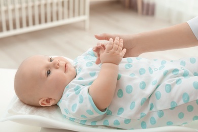 Doctor weighting baby on scales in light room