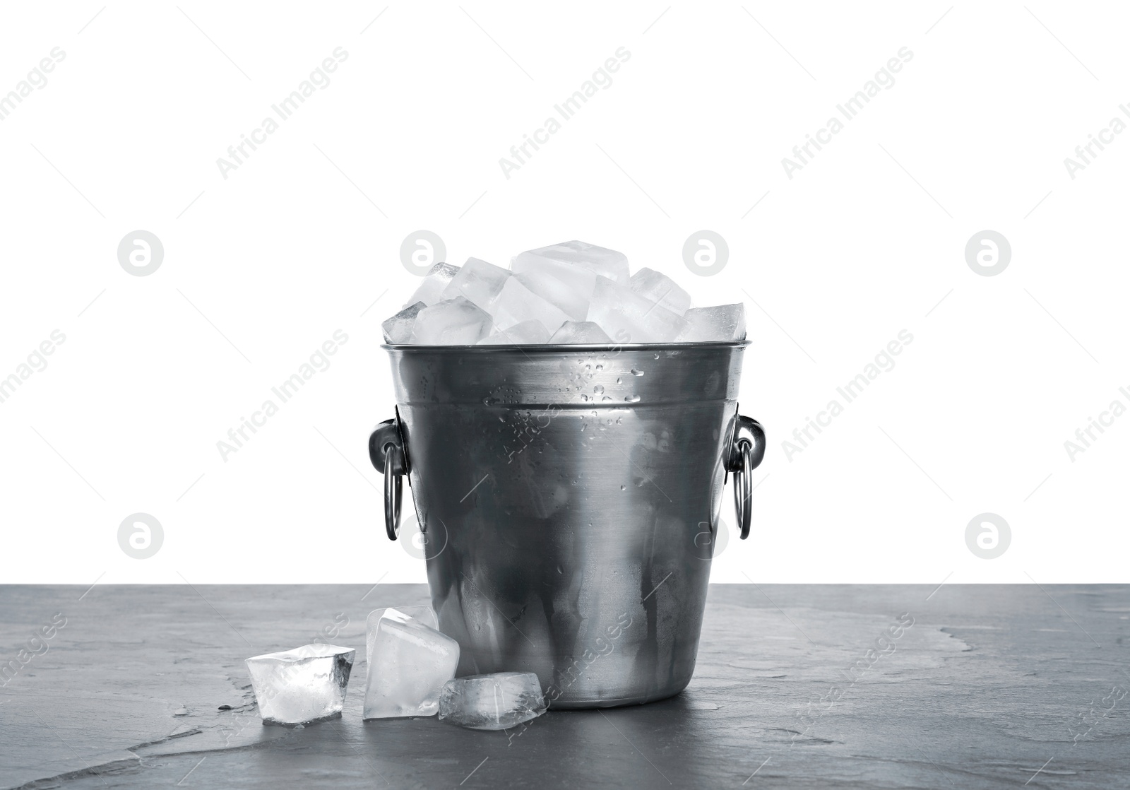 Photo of Metal bucket with ice cubes on table against white background