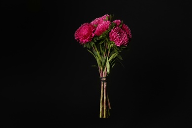 Bouquet of beautiful pink asters on black background. Autumn flowers