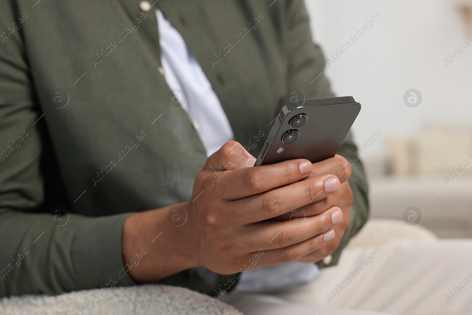 Photo of Man sending message via smartphone indoors, closeup