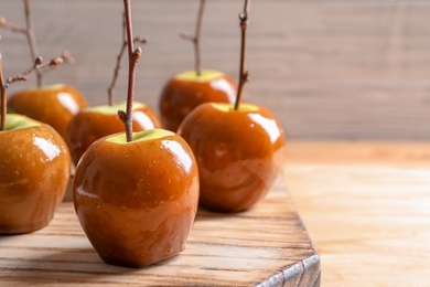 Delicious green caramel apples on table