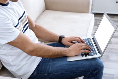 Photo of Man working on modern laptop at home, closeup