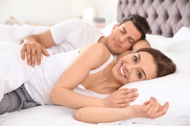 Photo of Lovely young couple resting on large comfortable bed