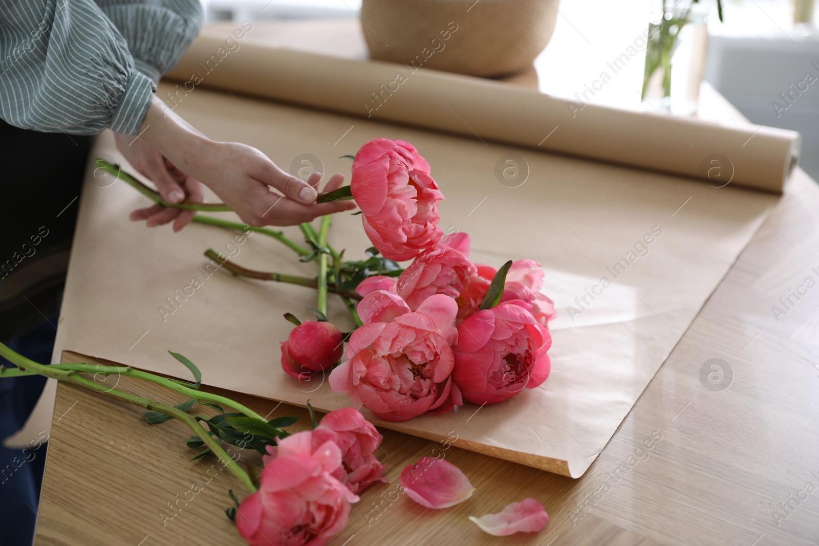 Photo of Florist making beautiful peony bouquet at table, closeup