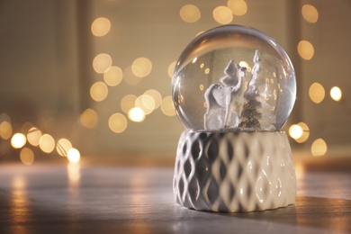 Photo of Christmas snow globe on table. Space for text