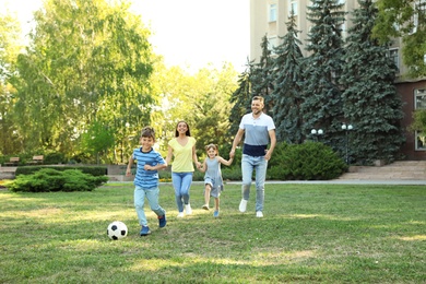 Happy family with children spending time together in green park on sunny day