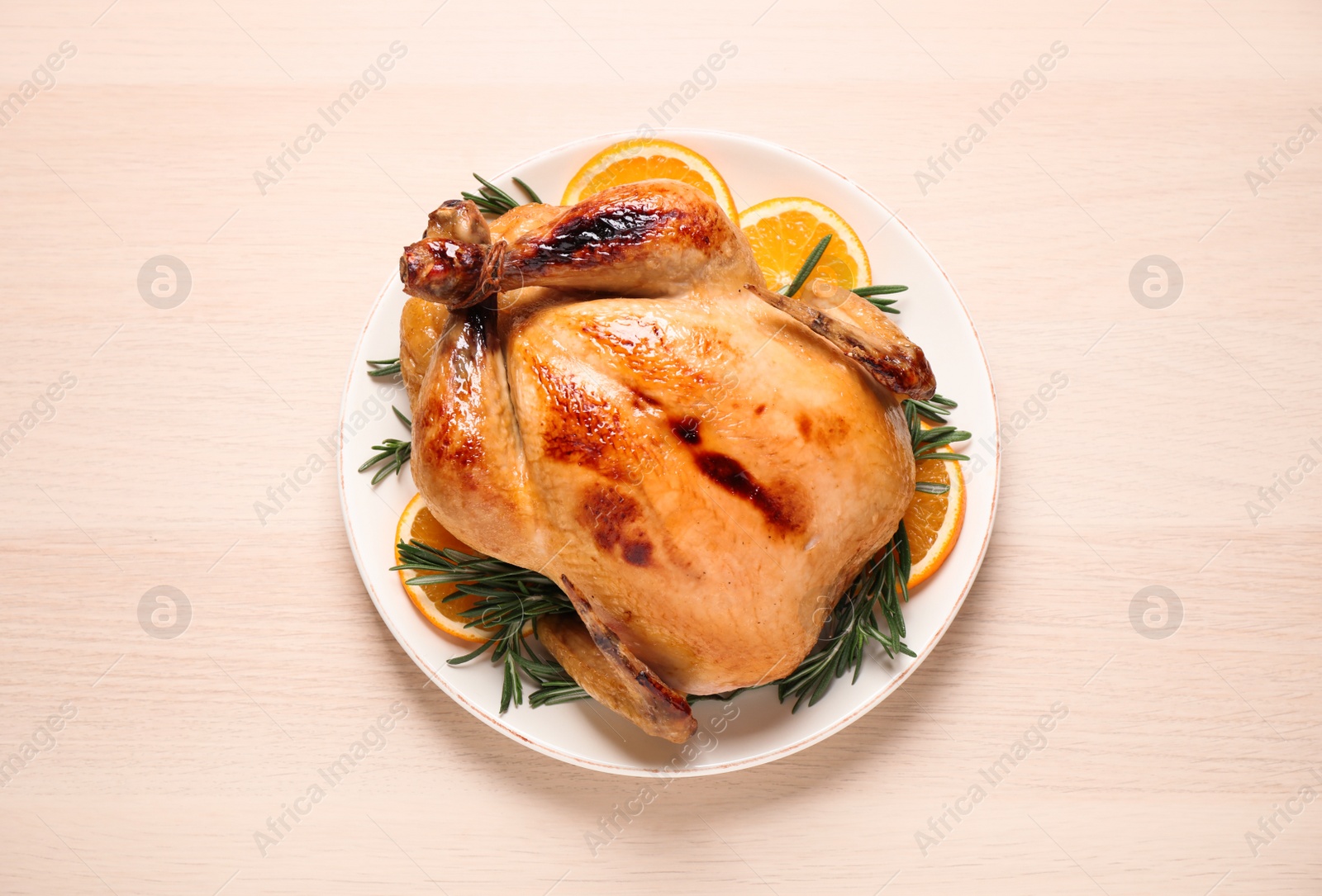 Photo of Delicious cooked turkey served on wooden table, top view. Thanksgiving Day celebration