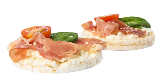 Photo of Puffed rice cakes with prosciutto, tomato and basil isolated on white