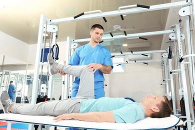 Photo of Physiotherapist working with patient in rehabilitation center