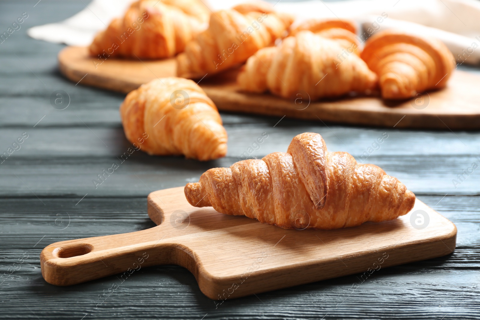 Photo of Fresh croissants on dark wooden table. French pastry