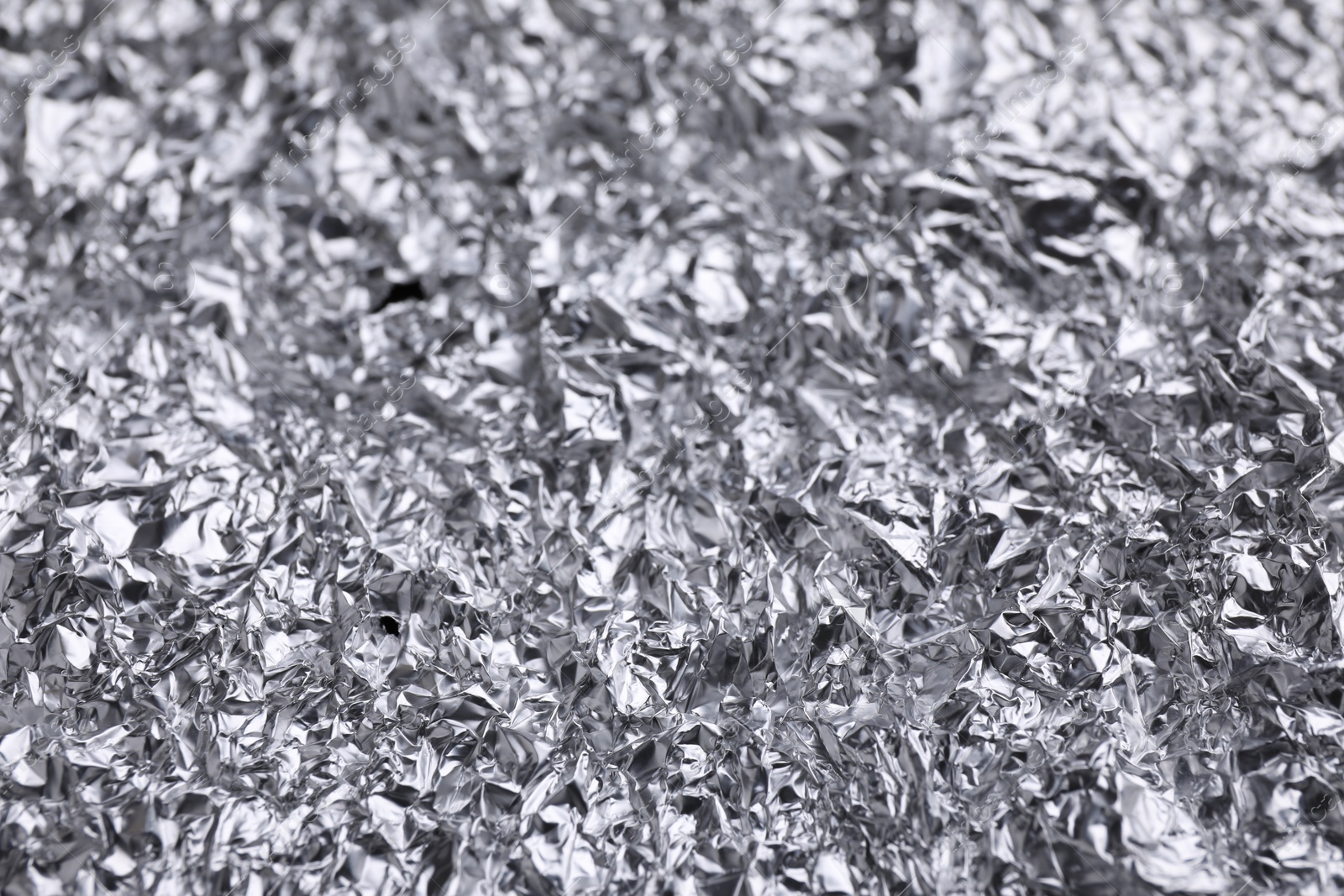 Photo of Crumpled silver foil as background, closeup view