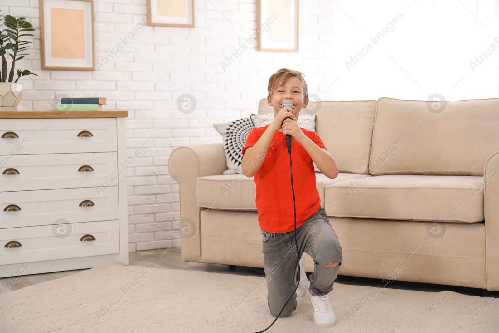 Photo of Cute boy with microphone in living room