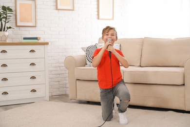 Cute boy with microphone in living room