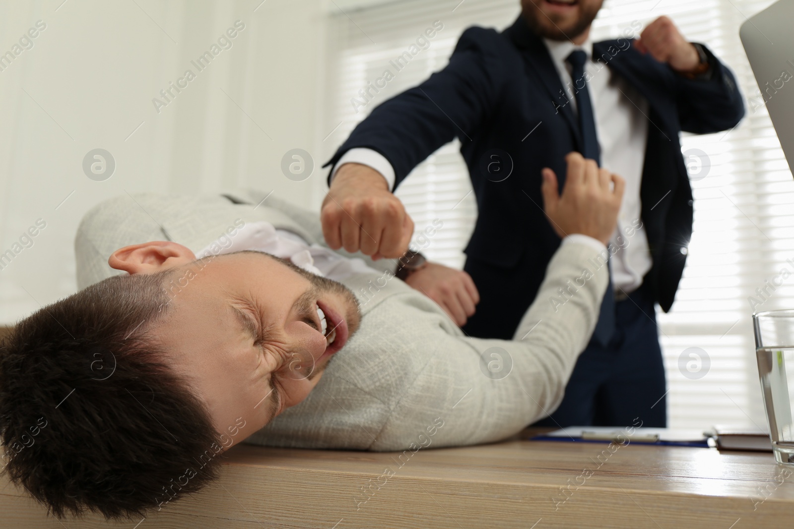 Photo of Emotional colleagues fighting in office. Workplace conflict