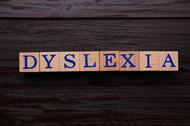 Cubes with word Dyslexia on wooden background, flat lay