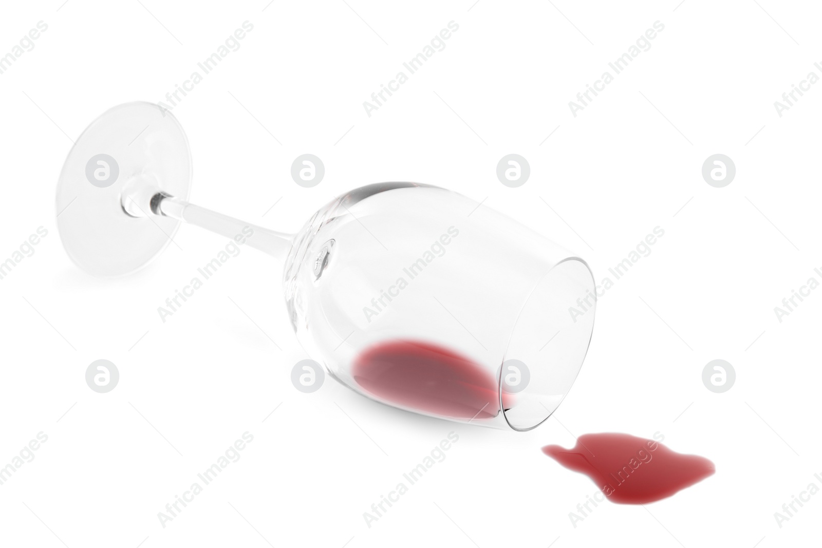 Photo of Transparent glass and spilled exquisite red wine on white background