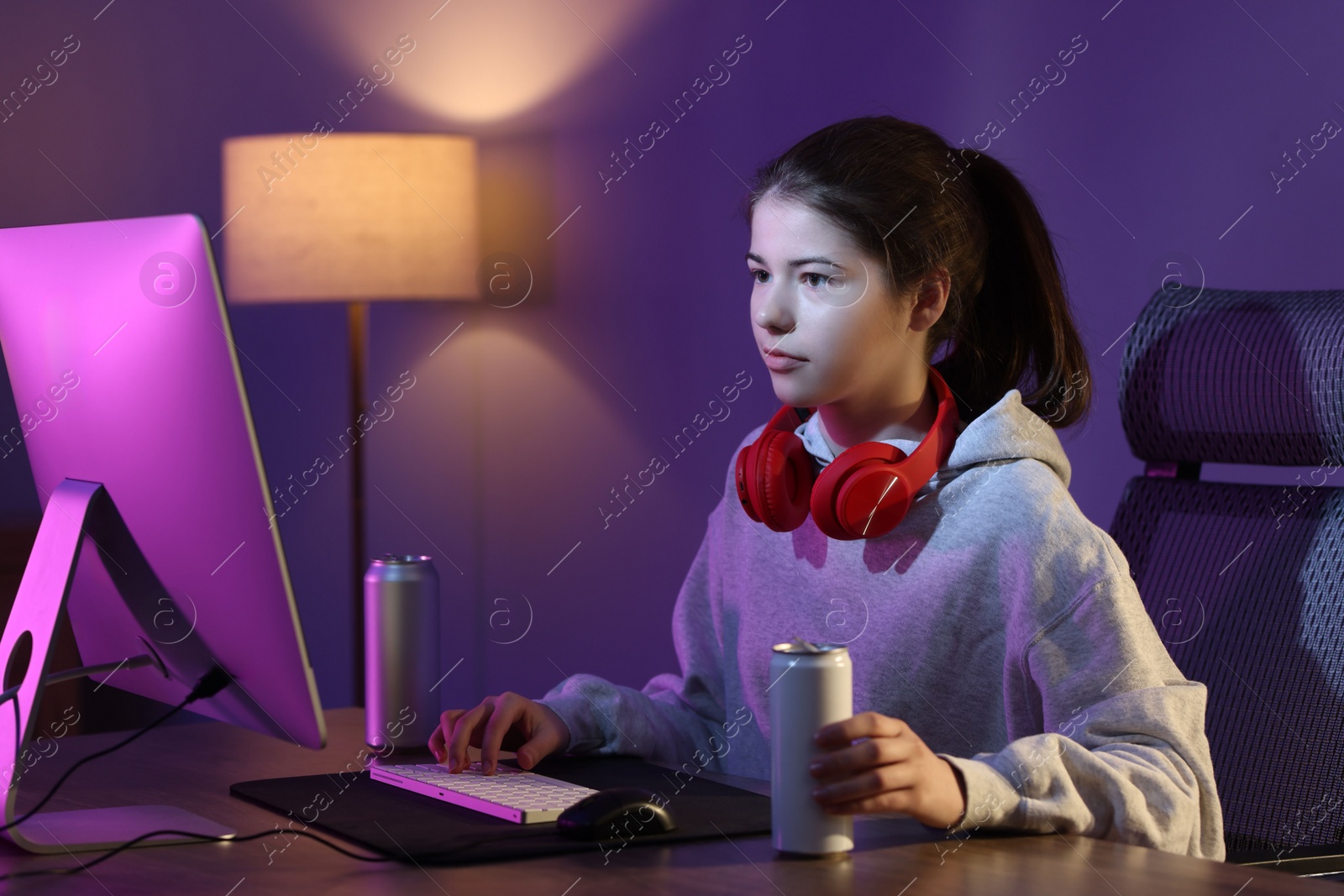 Photo of Girl with energy drink playing computer game at home