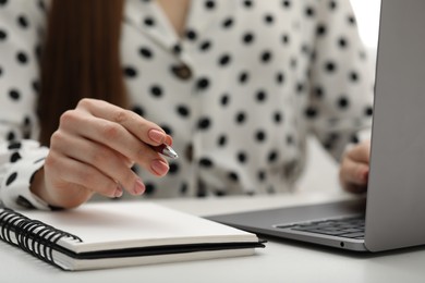 E-learning. Woman using laptop during online lesson at table indoors, closeup