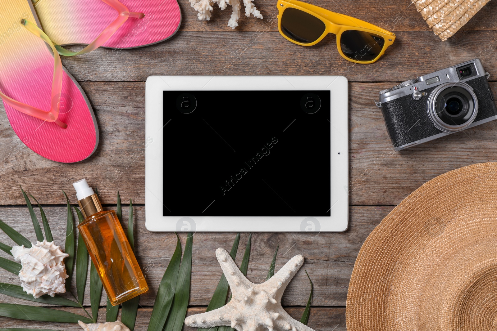 Photo of Flat lay composition with beach objects and tablet on wooden background