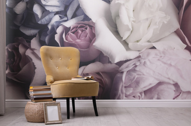 Photo of Beautiful room interior with stylish chair, books and floral pattern on wall. Space for text