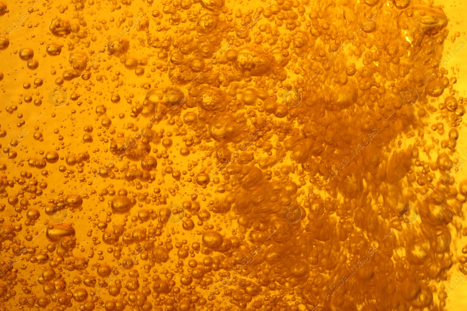 Photo of Tasty beer with bubbles as background, closeup