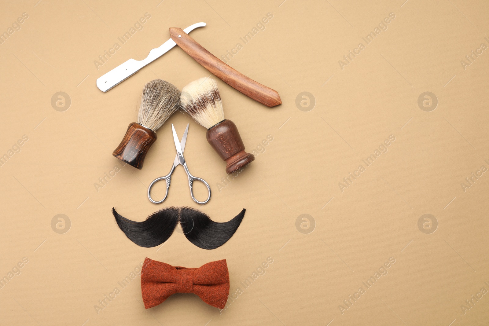 Photo of Artificial moustache and barber tools on beige background, flat lay. Space for text