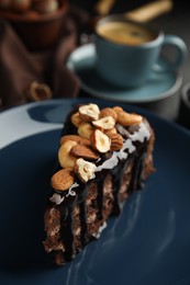 Piece of tasty homemade chocolate cake with nuts on plate, closeup