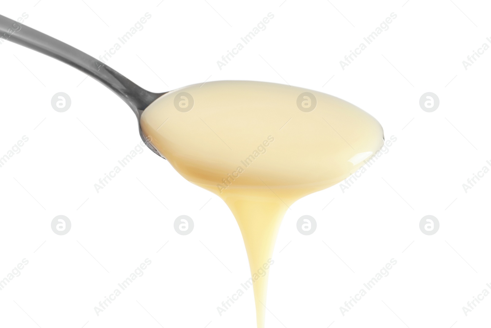 Photo of Spoon with condensed milk on white background, closeup. Dairy product