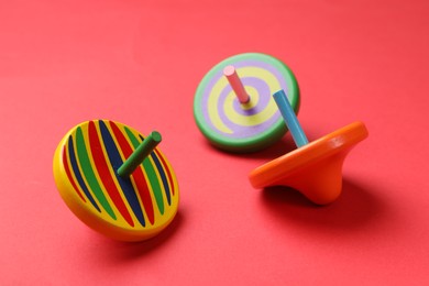 Many colorful spinning top on red background, closeup