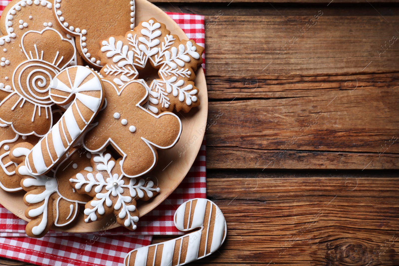 Photo of Delicious gingerbread Christmas cookies on wooden table, flat lay. Space for text