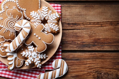 Delicious gingerbread Christmas cookies on wooden table, flat lay. Space for text