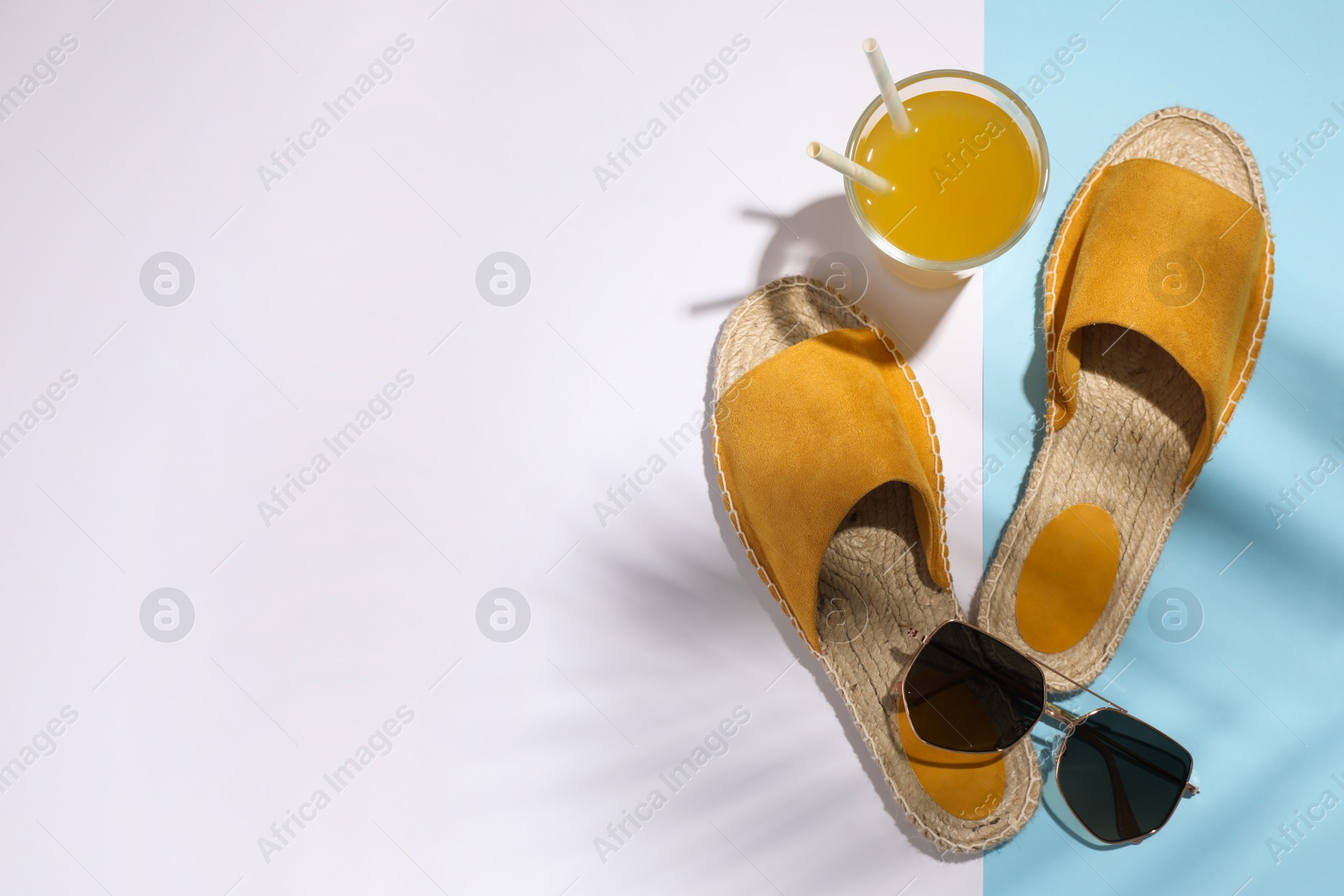 Photo of Stylish shoes, sunglasses and glass of juice on color background, flat lay with space for text. Beach objects