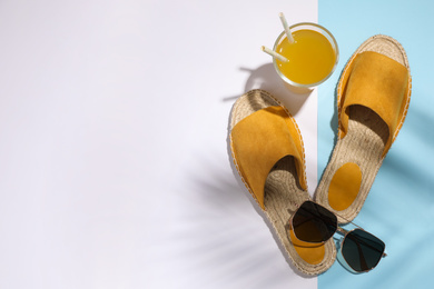 Photo of Stylish shoes, sunglasses and glass of juice on color background, flat lay with space for text. Beach objects