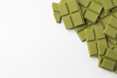 Photo of Pieces of tasty matcha chocolate bars on white background, top view. Space for text