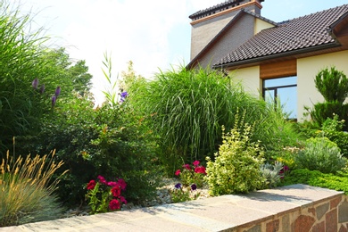 Landscape with modern house and beautiful garden on sunny day