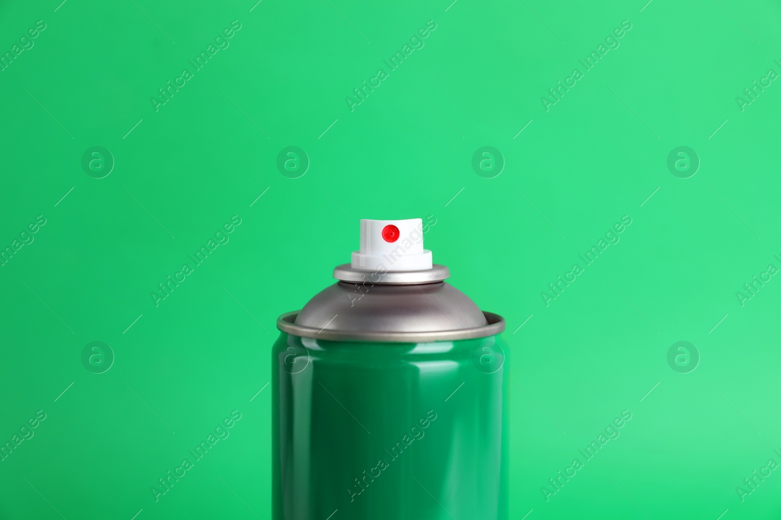 Photo of Colorful can of spray paint on green background, closeup