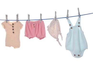 Photo of Colorful baby clothes drying on laundry line against white background