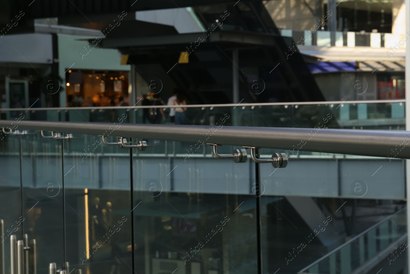 Photo of Glass barrier with metal handrail in modern building
