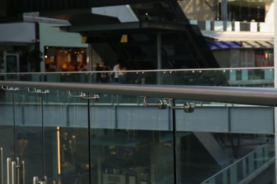 Glass barrier with metal handrail in modern building