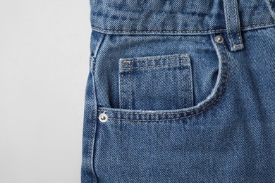 Jeans with pocket on light grey background, top view
