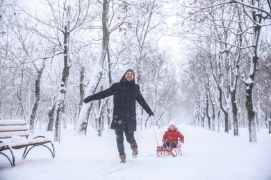 Father with his child spending time outside on winter day. Christmas vacation