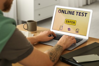 Photo of Man taking online test on laptop at desk indoors, closeup