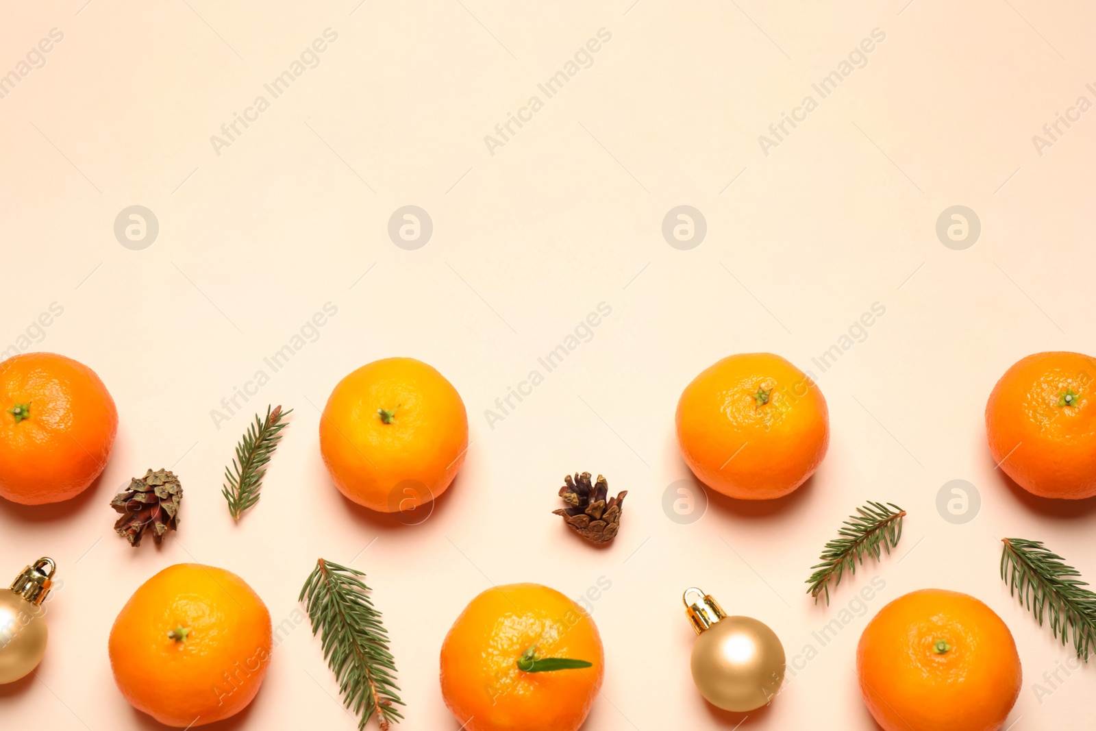 Photo of Composition with Christmas balls and tangerines on beige background, flat lay. Space for text