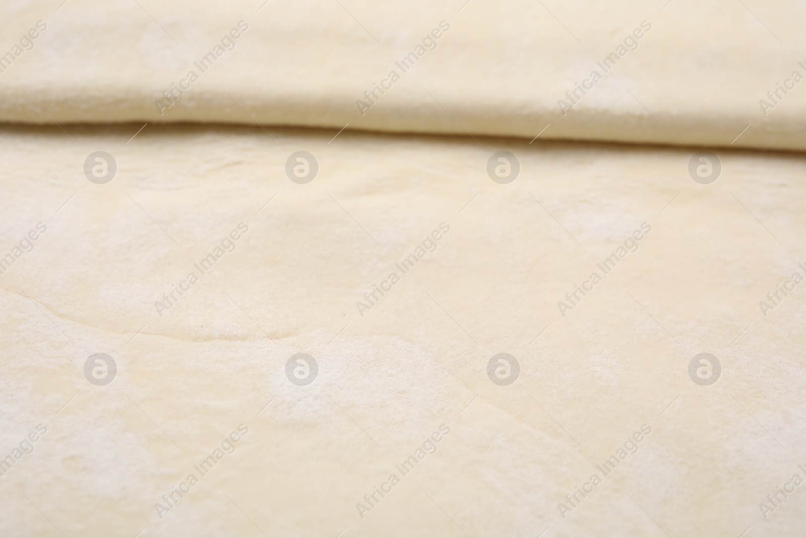 Photo of Raw puff pastry dough as background, closeup